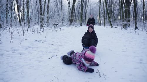 Children Sledding in a Snowy Forest