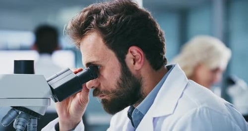 Focused Scientist Working with Microscope in a Laboratory