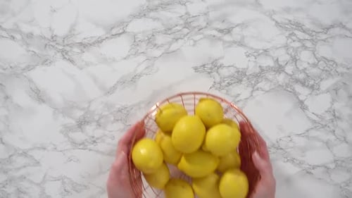 Flat Lay Step By Step Fresh Organic Lemons in a Wire Basket on a Marble Surface