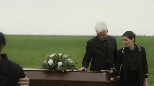 People Gather in Field at a Funeral
