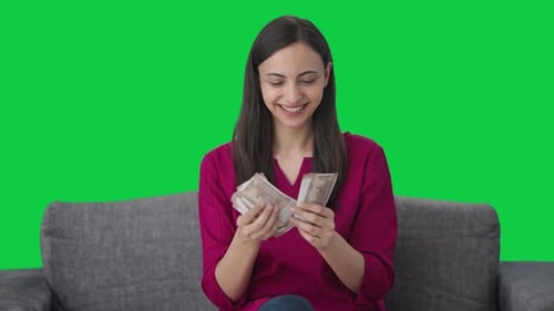 Happy Indian woman counting money Green screen