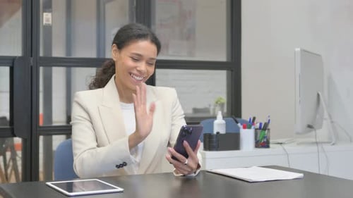 African Woman Doing Video Chat on Phone in Office