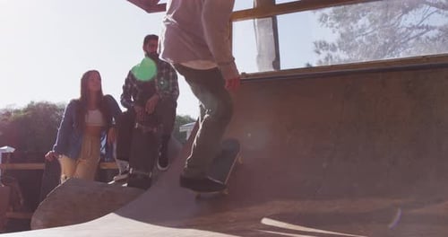 Video of happy diverse female and male skateboarders in skate park