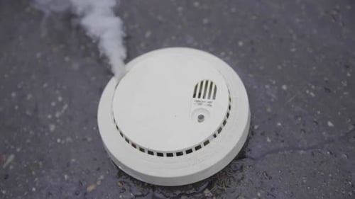 Smoking Smoke Detector on Gray Surface