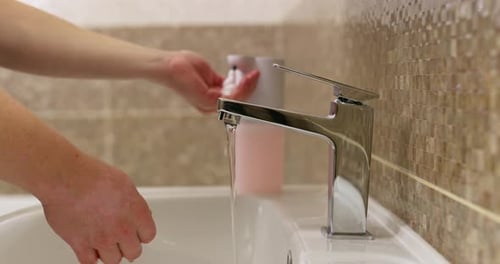 Washing Hands with Soap in Bathroom Sink