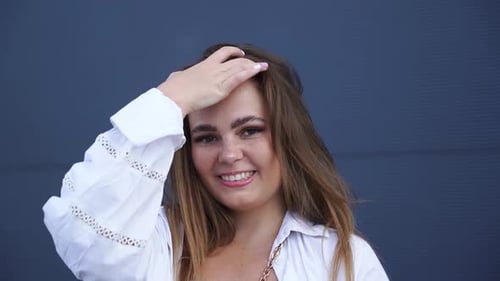 Portrait of young Caucasian girl in white shirt posing for camera. Close-up