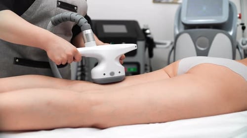 Anticellulite Massage with Modern Aesthetic Apparatus in SPA Salon Massaging Back Hips of Woman