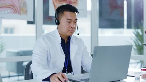 Médico generalista asiático con auriculares hablando a través de una computadora portátil, cámara web, videochat, conferencia