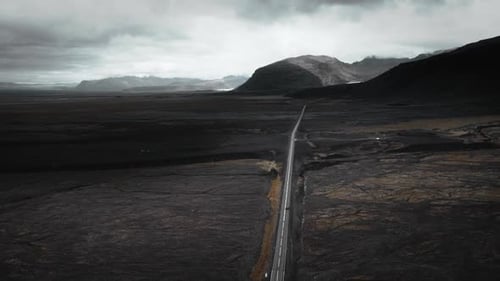 Long Road Cuts Through Dramatic Desolate and Moody Volcanic Landscape