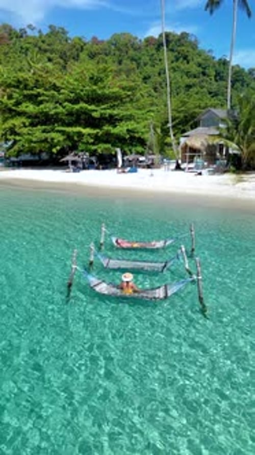 Relaxing on Hammocks Over Crystal Clear Waters of Koh Kood Island