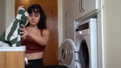 Woman Doing Laundry in a Small Laundry Room
