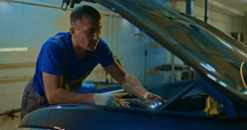 Man Working on a Car Engine in Garage