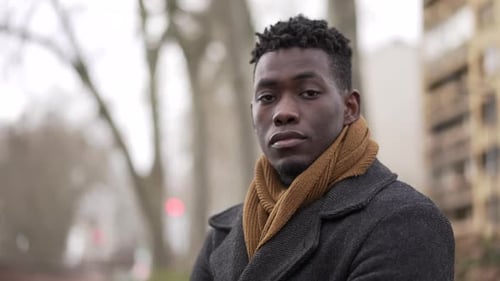 Confident African black man standing outside during winter season portrait staring camera
