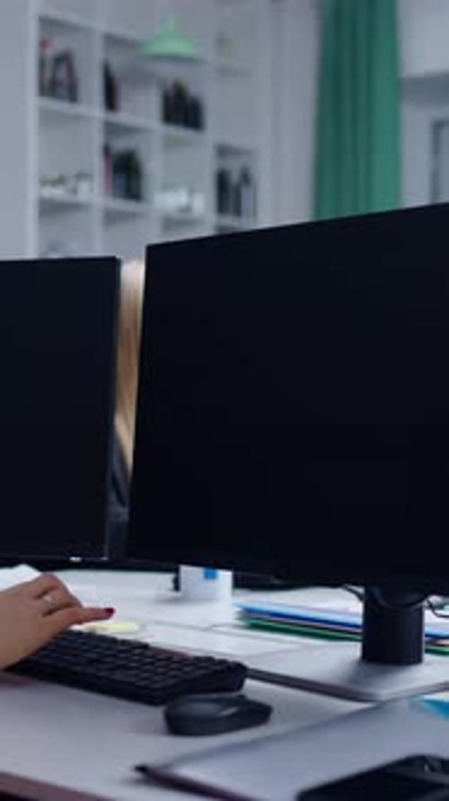 Environnement de travail ciblé Personnes engagées dans des tâches numériques sur des bureaux modernes équipés de deux écrans