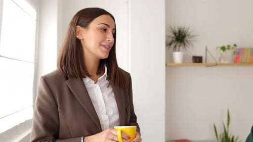 Two Colleagues Talking About Business on Break in the Office