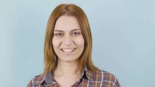 Smiling Woman Winking on Blue Background