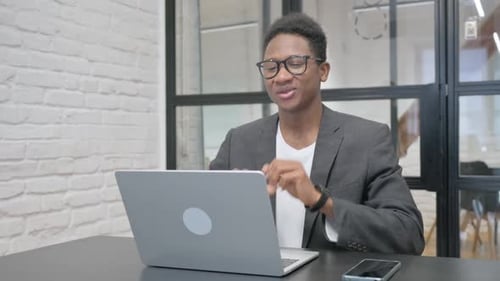 Young Adult Video Conferencing on Laptop in Office