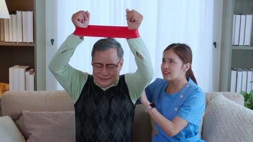 Senior Man Exercising with Assistance from Caregiver