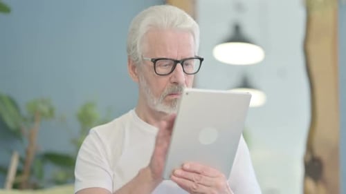 Senior Man Using Tablet Device Indoors