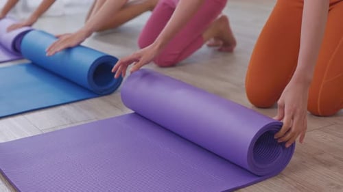 Close up of sportswoman keeping exercise mat in the fitness studio.