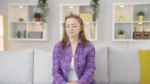 Woman Sitting on a Couch with a Serious Expression