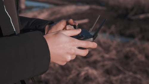 Person Controls Drone Controller Outdoors in Natural Setting