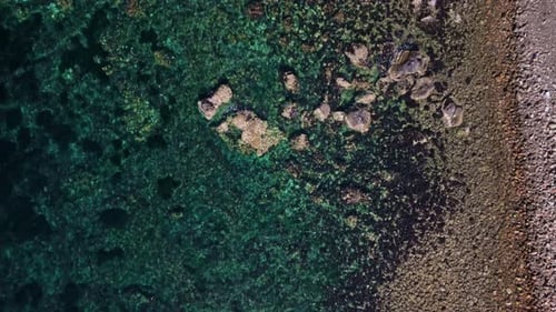 Aerial view of rocky shore and clear water, Italy.