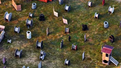Luftaufnahme eines taktischen Paintballspiels mit Spielern, die sich hinter Hindernissen verstecken