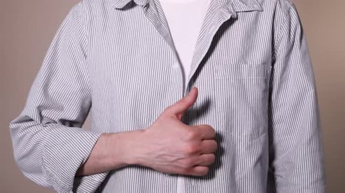 Man Gives a Thumbs Up Wearing Striped Shirt