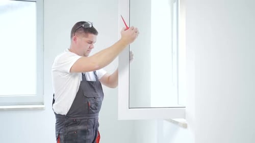 worker installs and adjusts a new plastic window in house. repair regulates Installation