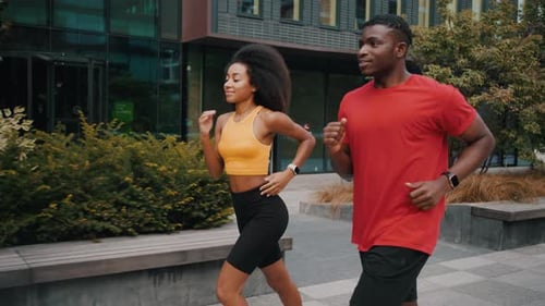 Athletic Pair Running Through the City