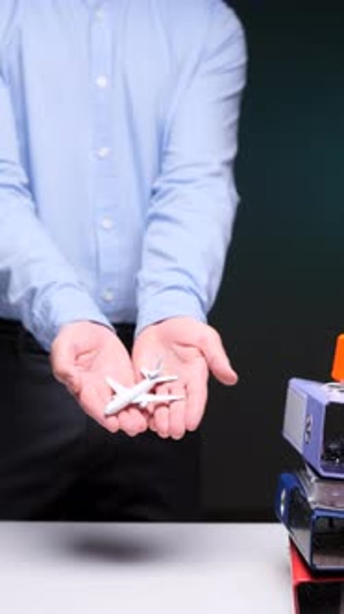 Vertical Video Businessman Presenting Model Airplane in Office Setting