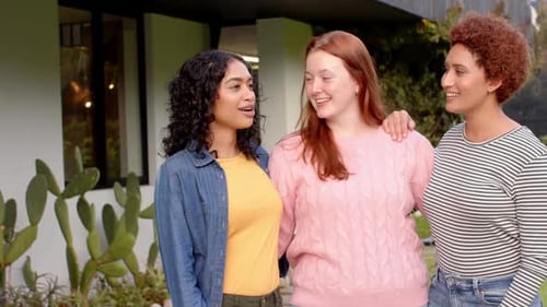 Happy Young Women Friends Embracing Outside Home