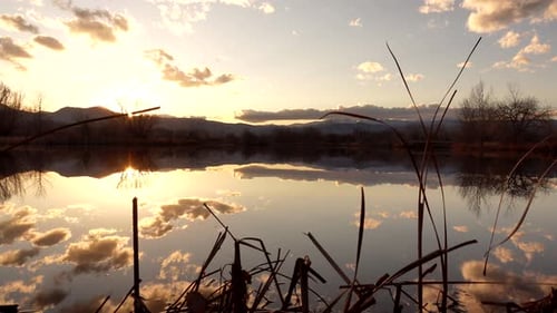Reflection of sunset and clouds over lake surface