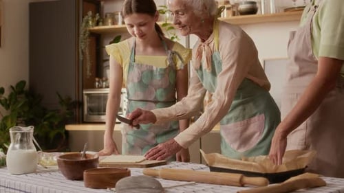 Grandmother, Mother, and Daughter Baking Together in Kitchen