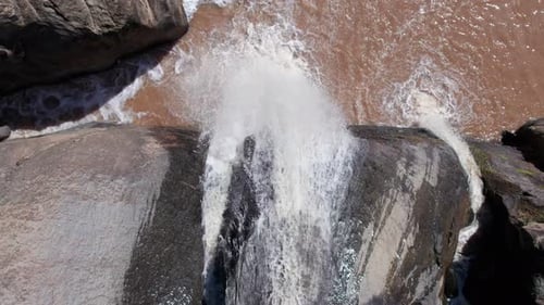 Closed shot of a waterfall flowing down from the hills and meeting the stream; many streams meeting