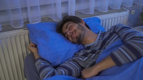 Jeune homme faisant des rêves heureux dans son sommeil.