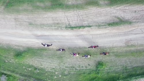 Horseback riding in a green Badlands terrain, aerial footage