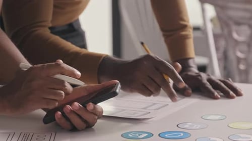 Mobile App Developers Using Smartphone and Writing on Sketches