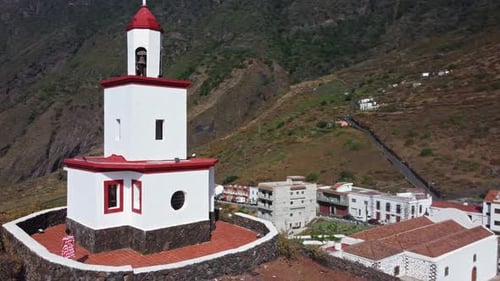 A igreja branca de La Candelaria com uma torre sineira elevada em uma colina na cidade com um visitante de