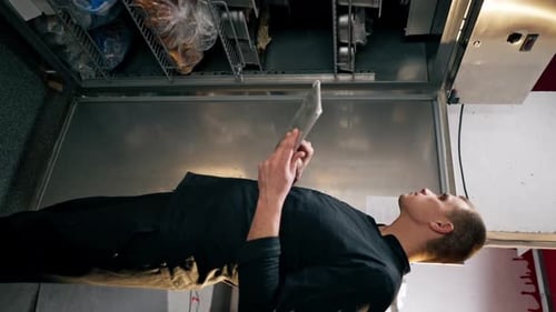 Man Using Tablet in Commercial Kitchen