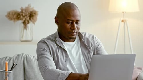 African American Millennial Man Working on Laptop at Home in a Cozy Setting