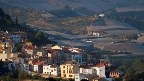 Mountain village scene with houses and greenhouses. Polop view, Spain