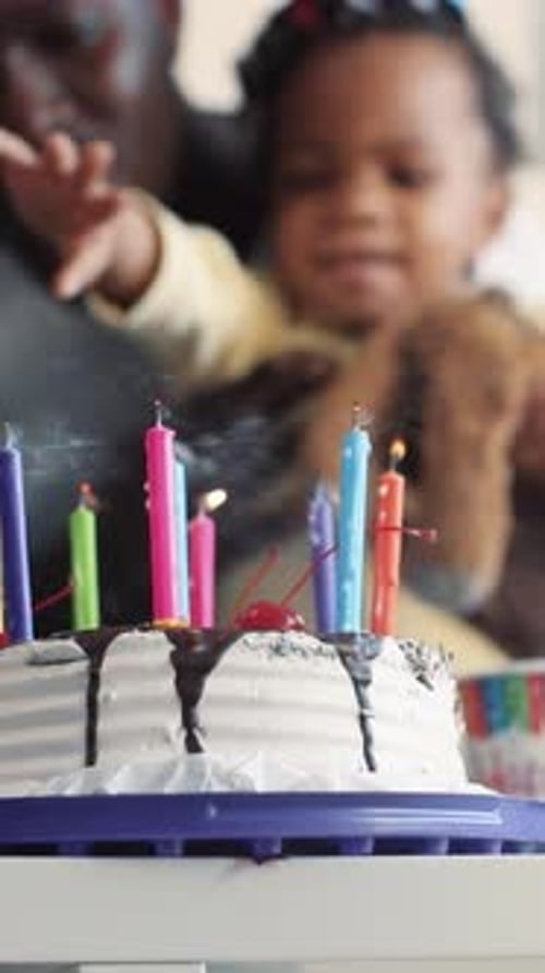Father And Child Blow Out Birthday Candles