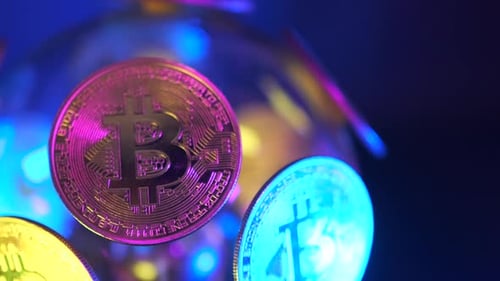 Pièces Bitcoin avec néons sur fond de boule électrique transparente à rotation lente.