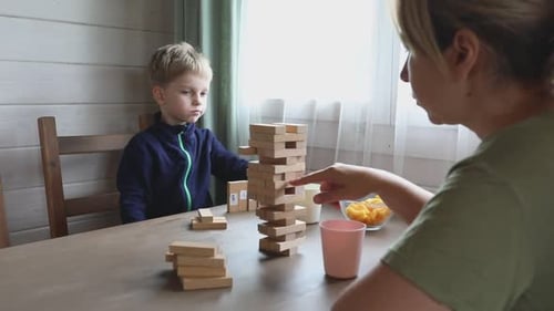 Mutter und Sohn spielen Jenga-Spiel zu Hause