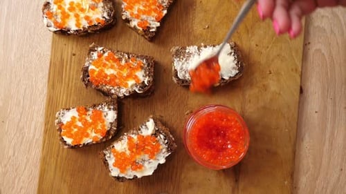 Making Delicious Caviar Sandwiches on Wooden Board