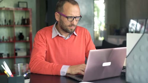 Young entrepreneur working on laptop and smartphone at home office