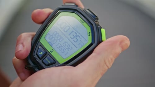 Hand Operating Digital Stopwatch to Track Time