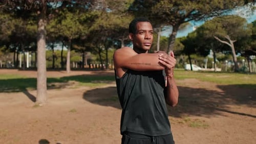 Young Man Stretching in Park Before Workout